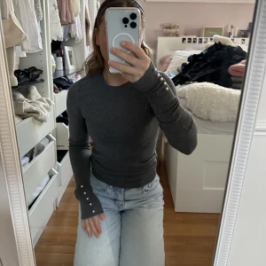 Grå tröja med pärlor - En grå långärmad tröja från zara. Med pärlor på armarna
