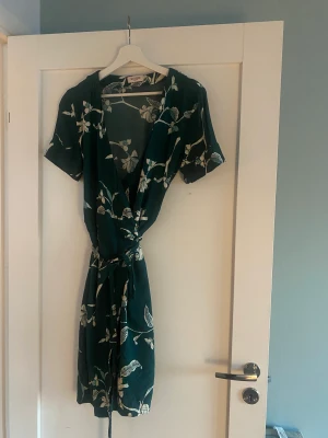 Omlottklänning Soaked - Grön och vit omlottklänning storlek M. Fint skick. 