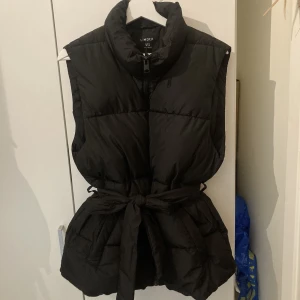 Väst med knytband storlek M - Svart väst med knytband i midjan. Köpt i höstas för 499kr, sparsamt använd och fin i skick.