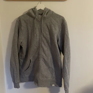 Grå Zip Hoodie - Tja, säljer denna zip hoodie från märket Solid för den blivit för liten. Superskön och stilren, inga tecken på användning. Köptes för 400 om jag minns rätt, säljer för 150kr. Hör av dig om du har några funderingar, mvh Carl.