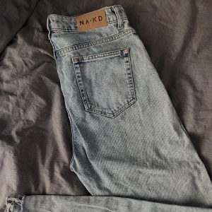 NA-KD Jeans - Säljer dessa blåa NA-KD Jeans. Har en liten slitning i bak, men det är inget som märks. Skriv för närmare bild! Hög midja, mom jeans, storlek 38