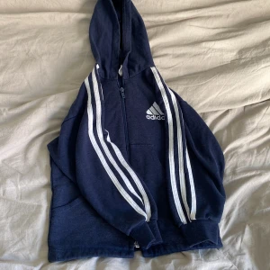 adidas jacka barn - jätte söt adidas kofta, i använt skick men fin och inga hål osvvvv. 62 cm runt om längst ner. Ärmens längd: 32cm dragkedjans längd : 38 cm