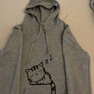 Jättesöt hoodie med ett kattmoriv på framsidan och kattöron. Knappast använd. Är tyvärr för stor för mig så därför säljs denna söta hoodien! 