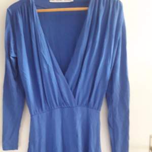 Djupt urringad blå klänning fin till sommaren 