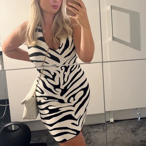 Klänning - Knyte i nacke och öppen rygg.