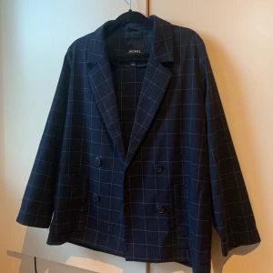 Kavaj  - Marinblå kavaj med rutmönster. Går att stänga och har fickor.