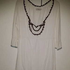 Klänning  - Säljer min sommar klänning/tunika från Cream. knappt anv nyskick. Vit med bruna detaljer. Mkt skön och mjuk kvalitet  kommer från rök och djur fritt hem inga defekter Nypris 1100