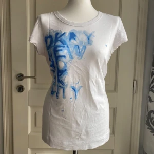 DKNY t-shirt - Snygg t-shorts med kvinnlig form ifrån DKNY. Sitter som en storlek S/M. Som ny!