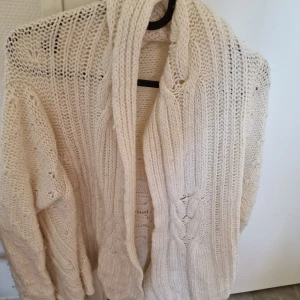 Kofta  - Kofta i beige lång utan knappar med smala ammar.  