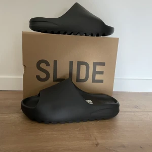 Yeezy slides - Yeezy slide onyx, vunna på adidas CONFIRMED. Box medföljer, kvitto finns. Helt oanvända, storlek 44,5. Nypris 1500+