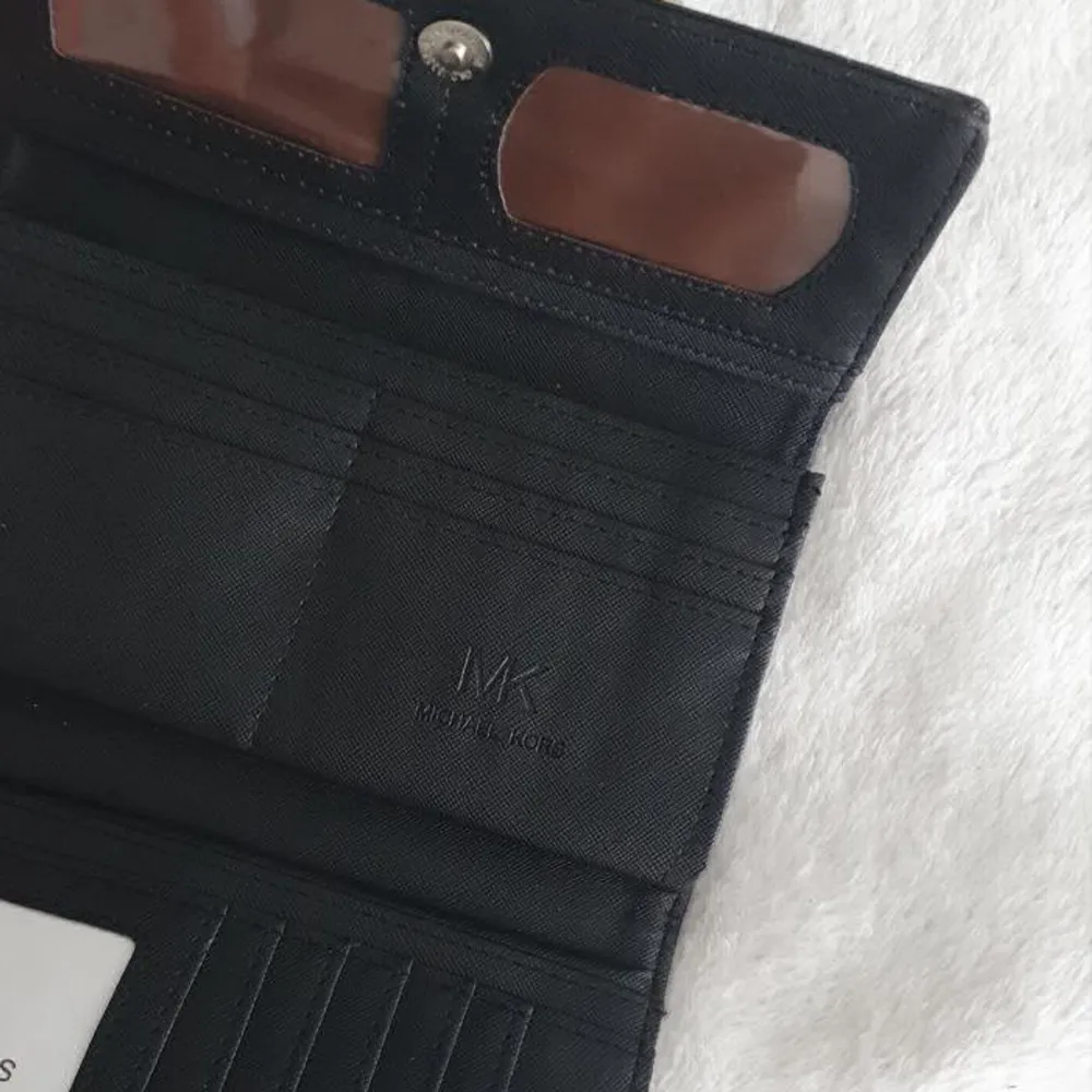 En svart plånbok MK.. Aldrig använd.  Kan tänka mig byta mot andra märkessaker. . Accessoarer.
