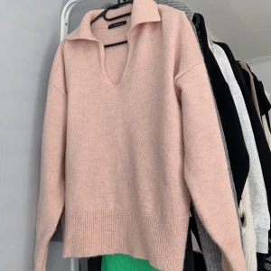 Stickad med krage - Säljer en stickad ljusrosa/babyrosa tröja med öppningar i ärm slutet och nertill på tröjan! 🥰 Skulle säga att tröjan passar en xs-m beroende på hur man vill att den ska sitta!  Så fin att ha över klänning elr kjol! ☺️  SKRIV VID INTRESSE