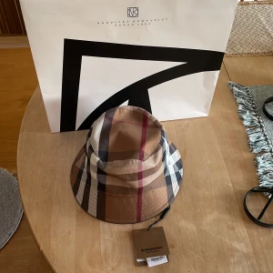 Burberry canvas bucket hat - Hej nu säljer jag min burberry canvas bucket hat i storlek medium den är i ny skick hör av er om nie intreserade😌 ni kan buda