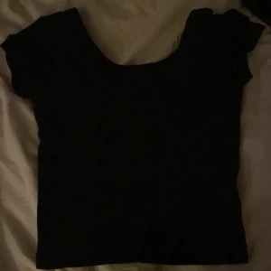 Svart topp - En svart cropad topp med en hyfsad öppen rygg, som är i bra skick och knappt använd. Storlek Xs. Köparen står för frakten💕