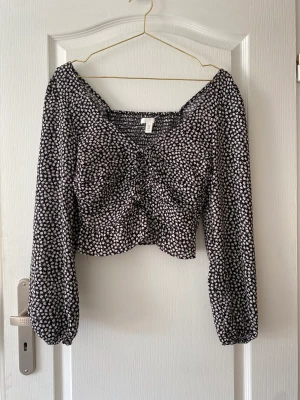 Blommig Blus - Säljer mig blommiga blus från H&M som inte har kommit till någon användning. Blusen har används 2-3 gånger och har inga defekter. På baksidan är den smockad i mitten vilket gör att det är stretchigt.