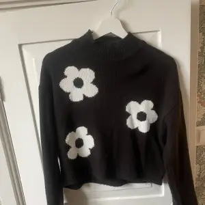 Jättefina svart stickad tröja med vita blommor på. Köptes hösten-22 o använd ca 5 ggr, därav i fint skick. Storlek XS, från HM nypris 200kr 