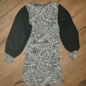 80s klänning - Klänning med mesh ärmar, lite genomskinlig. Fint mönster och har några stilrena cutouts runt halsen🙏 säljes då den inte passar mig.(hittar ingen storlek men skulle gissa S/M)