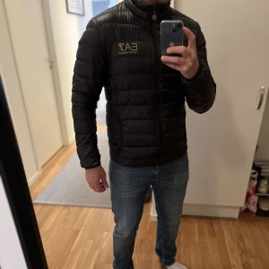 Armani jacka - Svart Armani jacka med EA7 i guld. Knappt använd och i nytt skick.