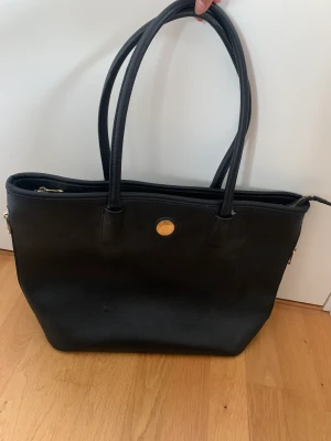Donna väska - Stor och rymlig axelväska, perfekt till vardags! Några år gammal men sparsamt använt och i bra skick!! Matchande plånbok hittar ni också på min sida☺️