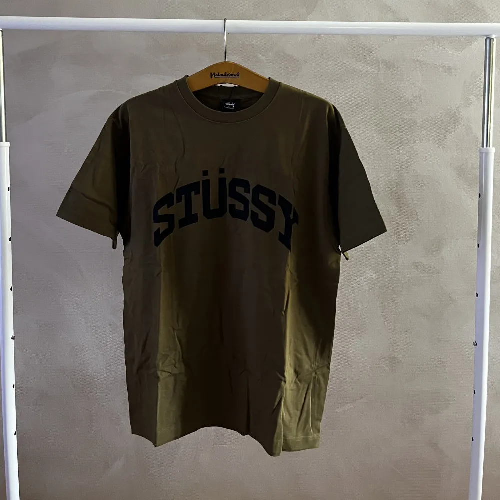 En grönbrun stussy tröja med vintage look och ett stort stussy tryck på bröstet Storlek large.. T-shirts.