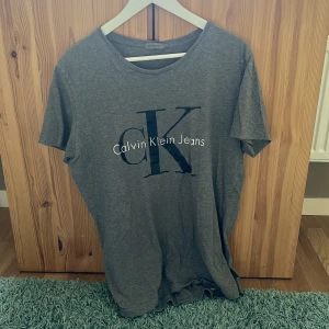 Calvin Klein T-shirt  - Äkta Calvin Klein T-shirt, knappt använd. Ett litet hål som bilden visar men annars i gott skick. XL. 