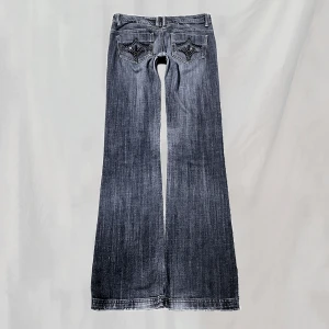 Lågmidjade jeans - Midja:82 innerben:85 Lågmidjade jeans med pärlor på bakfickorna. Raka ben. Stl w28. Stora samt långa på mig, svårt att visa fin passform. Lite små nötningar(bilder för ex). Nött och blekt i gren, något nött samt blekta bakre fotändar. Överlag bra skick🤍