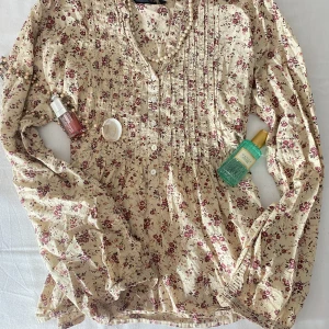 Beige blus med blommor  - Använt bara en gång