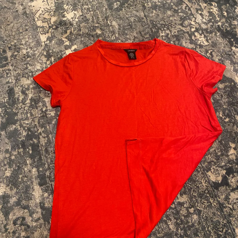 En röd T-shirt ifrån Lindex med lite blusigare material. T-shirts.