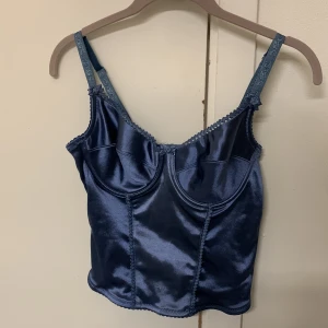 Blå korsett - En korsett/topp från 90-talet i silkes material och stretch💞 storlek 80B med rosdetaljer, pris kan diskuteras🫶🏼