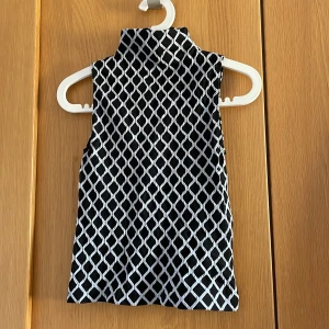 Linne - Mönstrat linne med halv polokrage. Supersnygg, sitter tajt, stilrent. Detta är ca en stl S