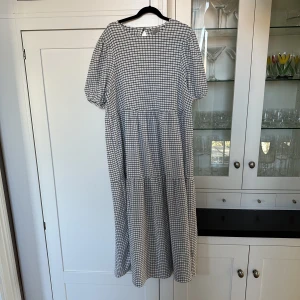 Asos Design rutig klänning smock XS - Säljer min superhärliga smock midiklänning från ASOS. Vit med svarta rutor. Ballongärmar. Väldigt smickrande! Köpt i England för £32 och har endast använts en gång. Storlek EU 32 - motsvarar ca S/XS, dock oversize i modellen så skulle passa även en M☺️