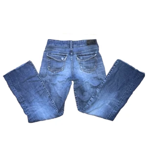 Lågmidjade jeans - Lågmidjade jeans med dubbla knappar på framsidan och snygga bakfickor. Innerbenslängd: 75 cm - Midjemått tvärs över: 36 cm