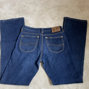 lågmidjade bootcut lee jeans - Så fina lågmidjade Lee jeans i den perfekta färgen, skicket är jättebra. De passar tyvärr inte mig så kan ej visa bild på men skriv om ni vill ha fler bilder på något🫶🏼🫶🏼🫶🏼 Midjemått: ca 37cm Innerbenslängden: ca 83 cm