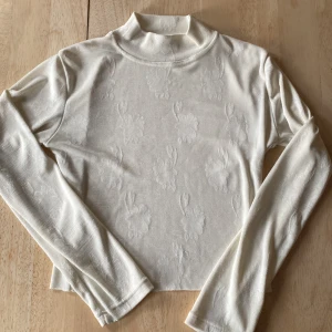 Vit tröja med blommor på  - Vit tröja med blommor på, är avklippt på längden  