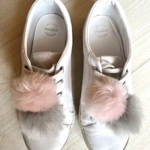 Sneakers vita  - Vita sneakers från Pull & Bear. Använda men i bra skick, syns dock att de är använda såklart. Fler bilder finns. ”Tofsarna” går att ta av om så önskas. 