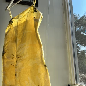 Klänning Hm - Jättesöt klänning från Hm med solrosor, bara använd en gång. Den går till halva låret på mig som är 166. 
