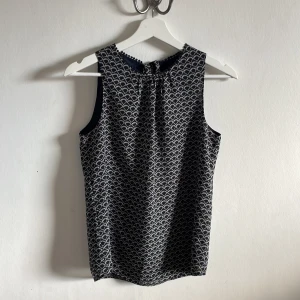 Kortärmad blus - Kortärmad blus med mönster Öppen i rygg med knyte upptill 