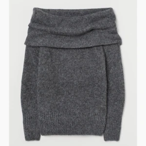 Stickad off shoulder tröja ny skick  - En finstickad tröja i mjuk kvalitet med inslag av alpacka. Tröjan har bred, nedvikt kant upptill och bara axlar. Lång ärm samt ribbstickad mudd vid ärmslut och i nederkant.