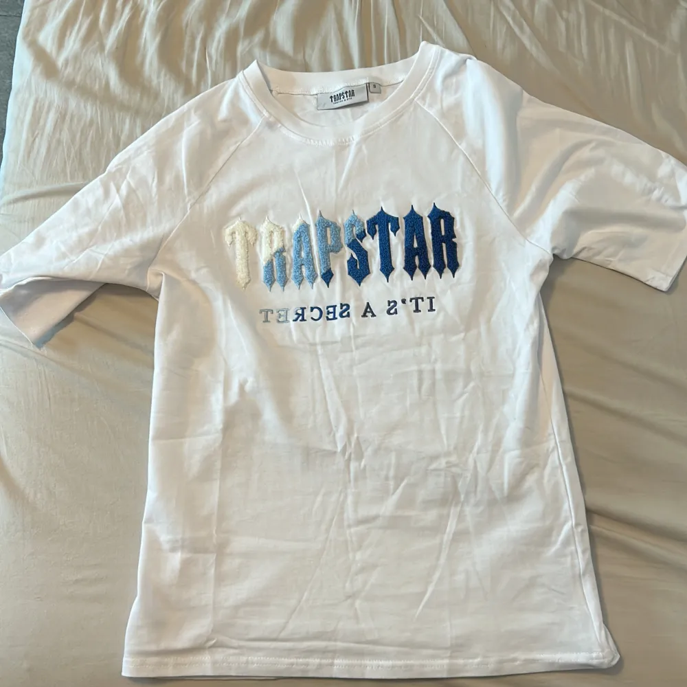 En vit oanvänd trapstar T-shirt. Säljer pga för liten storlek. Storlek S. Jättebra kvalitet. . T-shirts.