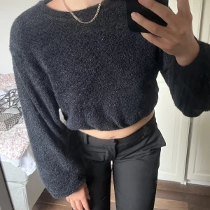 Svart lurvig tröja - Croppad svart tröja i ”fluffigt” material. Så skön och inte alls stickig. Köpt på Gina och aldrig använd. Snygg med t.ex ett vitt linne under.