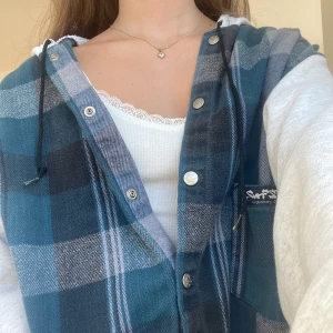 Flanellskjorta med luva knappar - Grönrutig Flanellskjorta med grå luva och ärmar från Surf Style🏄‍♂️🌴svart snöre i luvan och sex knappar samt en ficka på framsidan👕säljer då den inte kommer till användning 