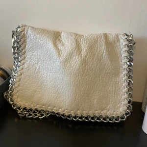 Vit Tiamo väska - Säljer min vita Tiamo väska, köptes på plick för 1 år sedan och säljs då jag inte använder den längre.  Begagnat skick då det börjat släppa lite på baksidan men fullt fungerande.  200kr plus frakt