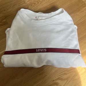 Vit croppad sweatshirt ifrån Levis  - Snygg croppad sweatshirt ifrån Levis i storlek M. Fint skick!  Mer bilder kan skickas privat vid intresse.  