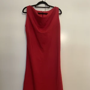 Ljuvlig röd klänning  - Fin klänning i rött med fin skärning i halsen. Går nedan för knät. 
