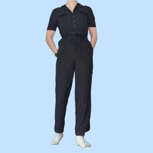 Svart byxdress - Svart byxdress i lätt material. Storlek 36 fråm Ginatricot. Snörning i midjan. Jag som har på den är 170cm lång