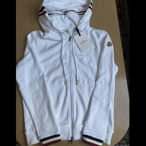 Moncler Kofta - Vit Moncler Kofta. Bästa kvalite. Tungt och fint matrial. Den har storlek 3 som är alltså L. Den ser fräscht ut. Den har NFC. är du intresserad? Isf tvivel inte att skriva till mig :)