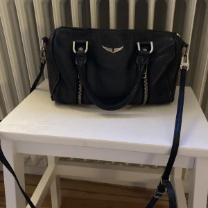 Zadig väska  - Säljer nu min fina zadig väska. Lite sliten men har fortfarande mycket att ge. Ett längre band medföljer. På bild 2&3 kan ni se slitningarna  Kan gå ned i pris vid snabb affär 