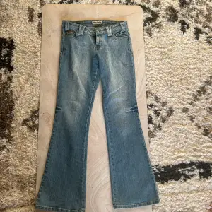 Lågmidjade y2k jeans med cool design fickorna 10/10 skick. Midjemått 37.5 mätt rakt över. Innerbenslängd 81cm