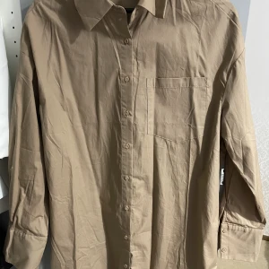 Blus  - Säljer denna fina kaki blus. Jag fick den som present men den har inte använts eftersom jag hade samma blus i min garderob. Den är mycket bra kvalitet. 