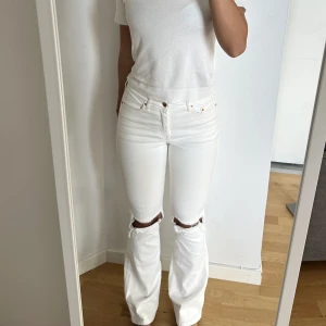 Bootcut jeans med hål - Vita bootcut jeans med hål vid knäna. Super coola och bra skick!